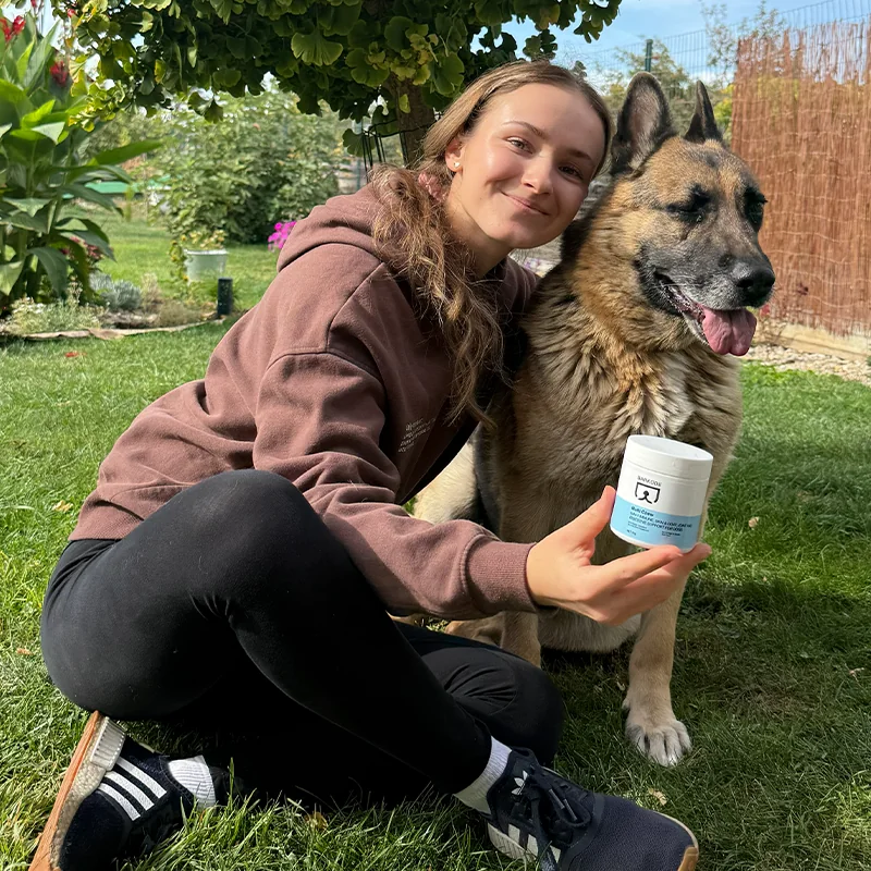 Owner sitting in the garden with her German shepherd and a jar of Multi Chew